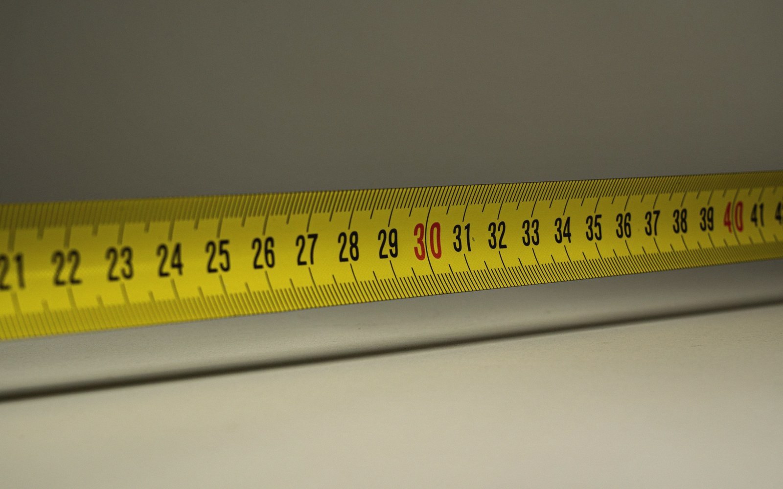 Yellow tape measure showing centimeter markings from 21 to 40 in close-up